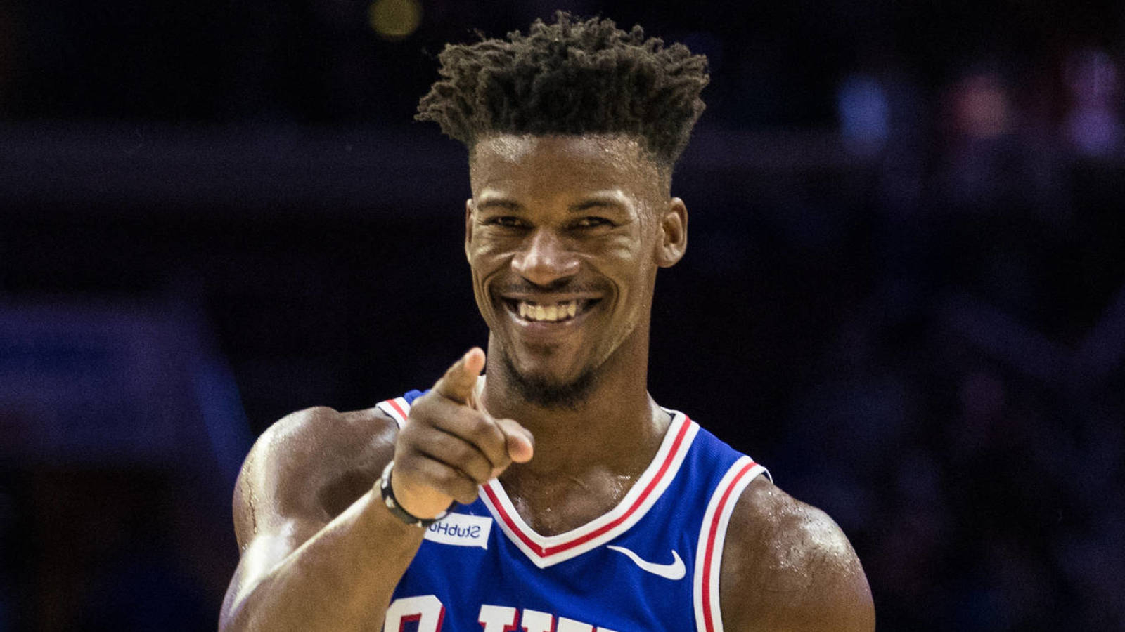 Jimmy Butler jovially pointing towards camera in 76ers uniform
